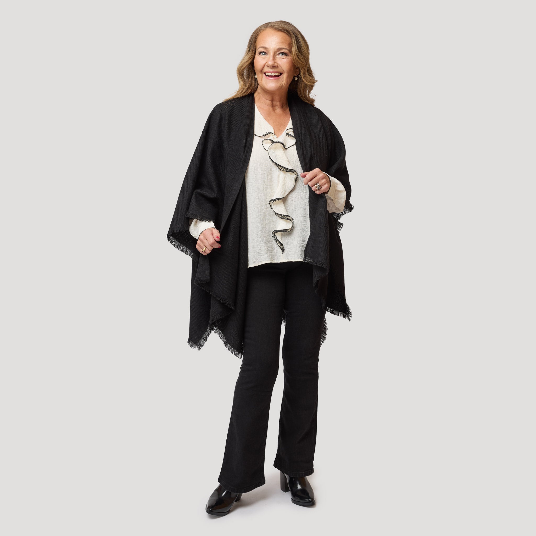 Vit blus med svart kant i kombination med svarta jeans.