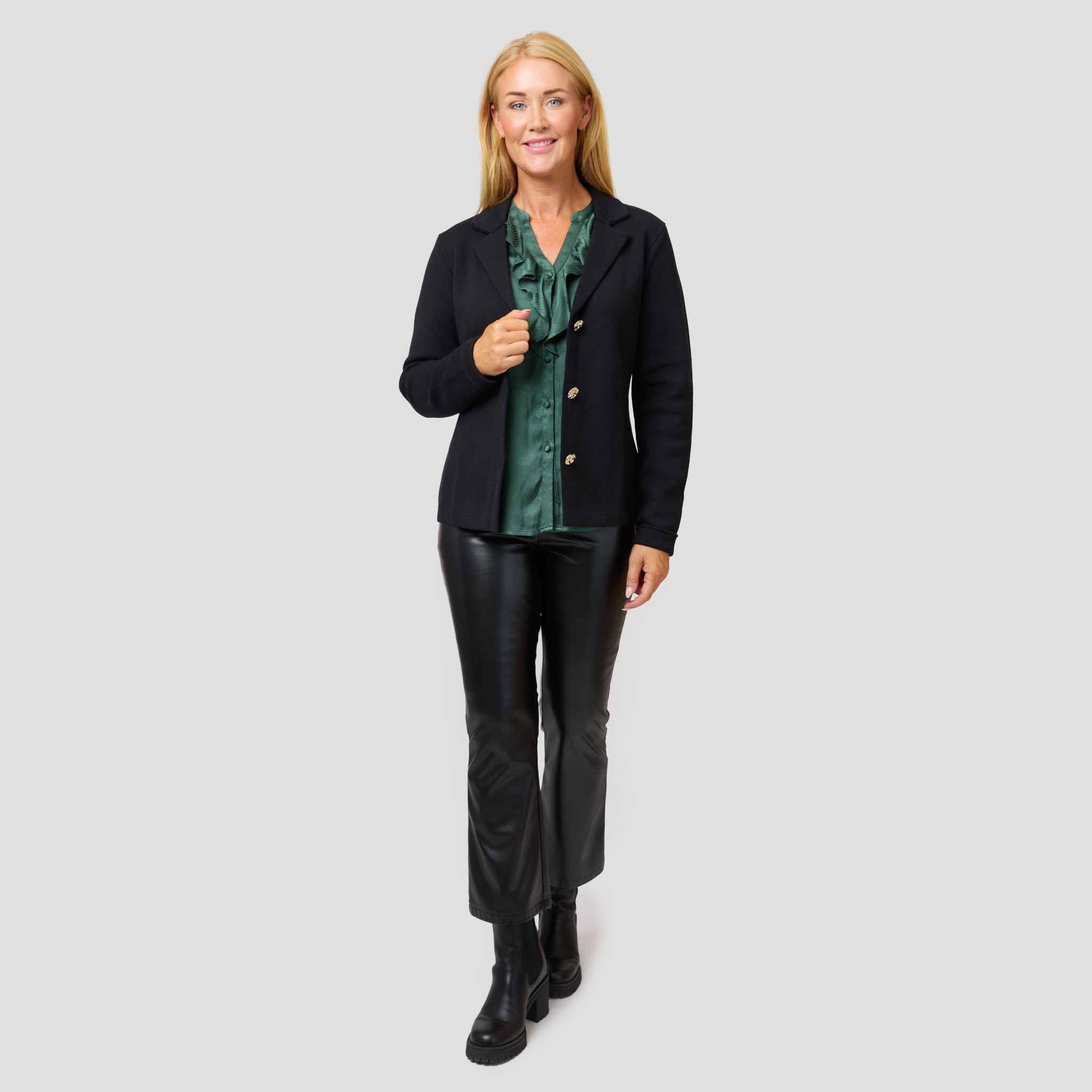 Casualbyxor med grön blus under svart stickad kavaj